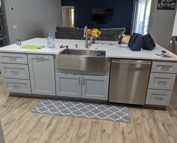 kitchen island with quartz countertop, bags on top, dishwasher, new cabinet installation