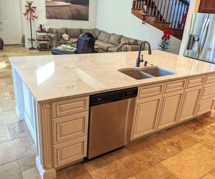 beautifully remodeled huge kitchen island that has a marble countertop and signature pearl cabinet doors